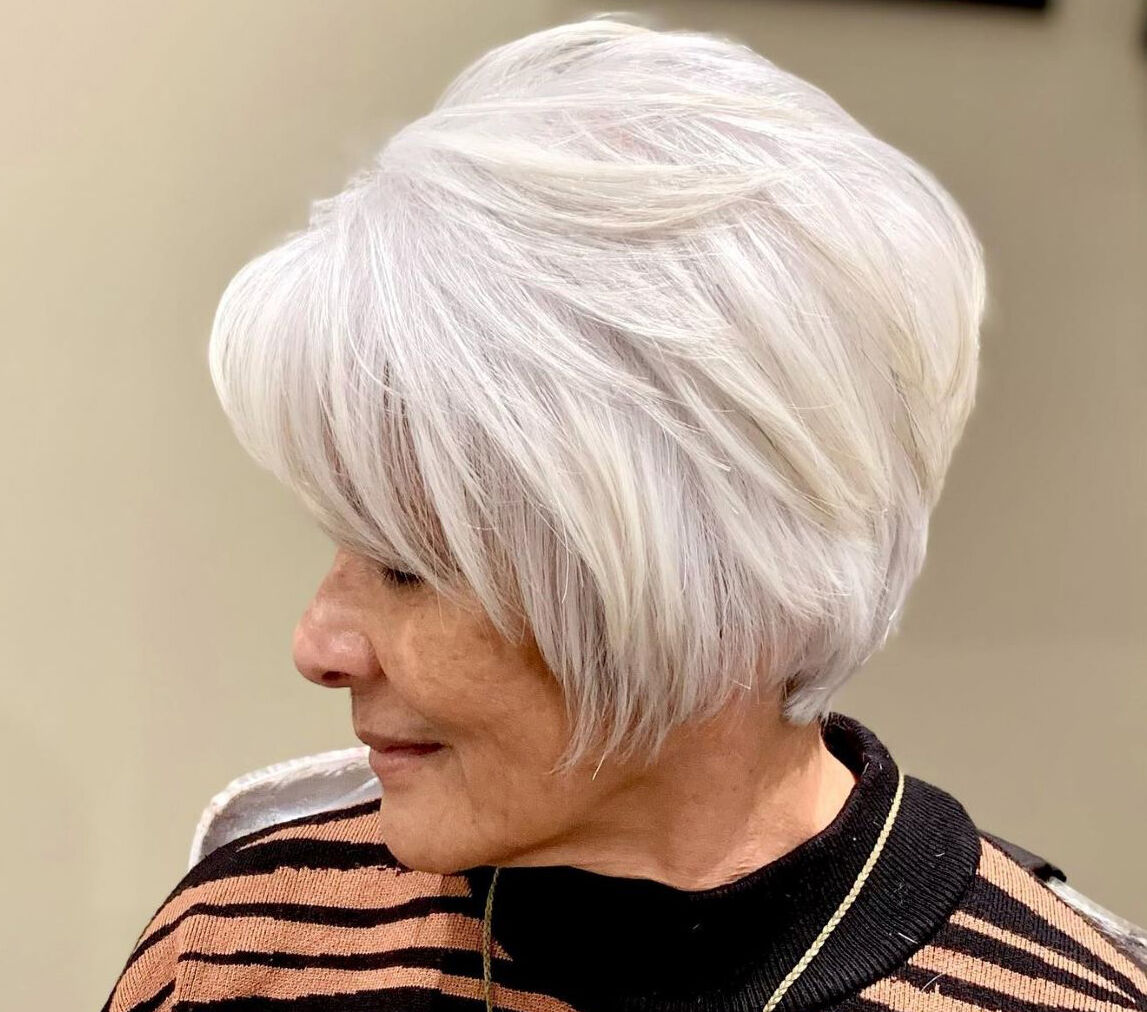 A stylish and modern haircut with a silver hue on an individual looking away from the camera.